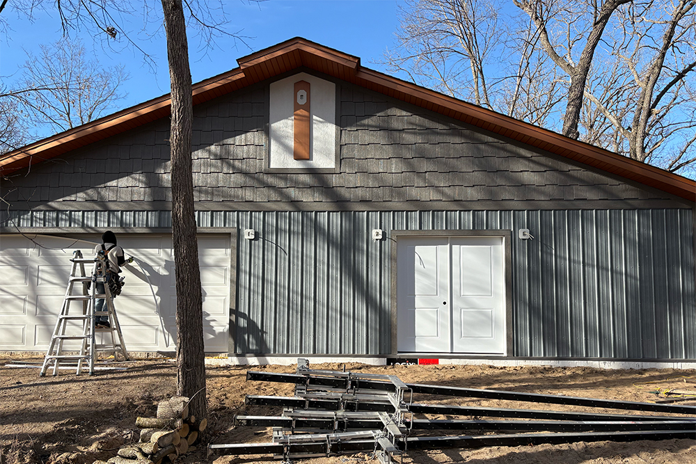 garage with new corrugated steel siding and metal shingles